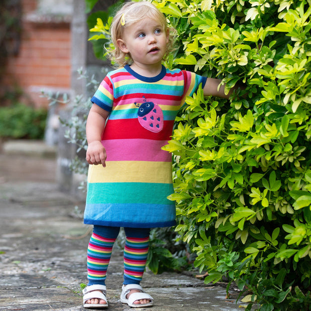 Girl in rainbow knit dress